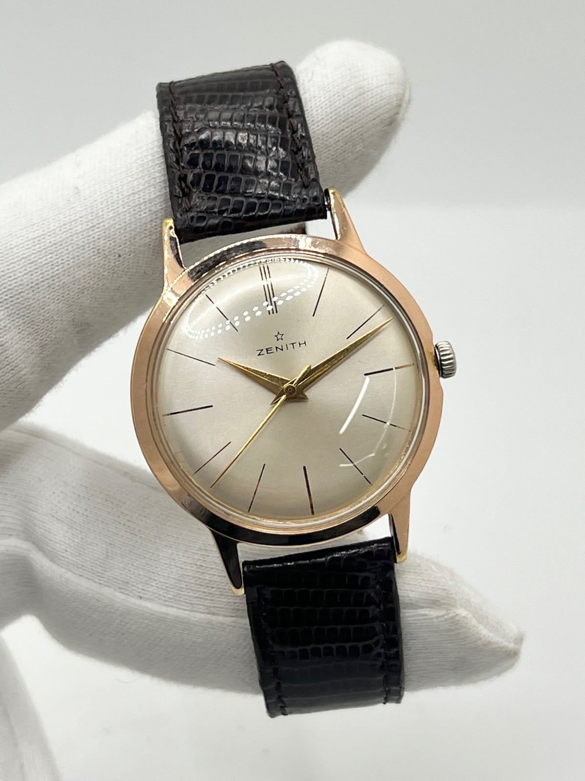 Montre Zenith Stellina vintage à remontage manuel, dotée d’un boîtier plaqué or et d’un élégant cadran champagne. Cette montre Zenith se distingue par son style classique et intemporel, emblématique de l’horlogerie traditionnelle. Elle est équipée d’un bracelet brun en cuir de lézard, complété par une boucle ardillon en acier. Avec son esthétique raffinée et son allure rétro, la Zenith Stellina séduit les amateurs de montres anciennes et de pièces horlogères au charme authentique.