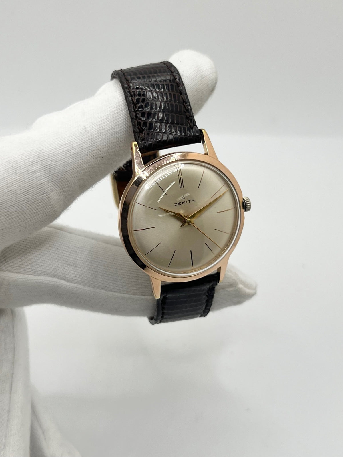 Montre Zenith Stellina vintage à remontage manuel, dotée d’un boîtier plaqué or et d’un élégant cadran champagne. Cette montre Zenith se distingue par son style classique et intemporel, emblématique de l’horlogerie traditionnelle. Elle est équipée d’un bracelet brun en cuir de lézard, complété par une boucle ardillon en acier. Avec son esthétique raffinée et son allure rétro, la Zenith Stellina séduit les amateurs de montres anciennes et de pièces horlogères au charme authentique.