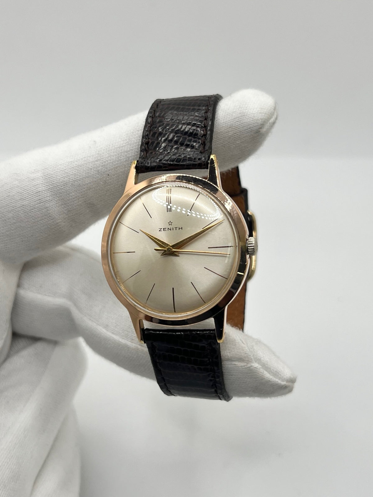 Montre Zenith Stellina vintage à remontage manuel, dotée d’un boîtier plaqué or et d’un élégant cadran champagne. Cette montre Zenith se distingue par son style classique et intemporel, emblématique de l’horlogerie traditionnelle. Elle est équipée d’un bracelet brun en cuir de lézard, complété par une boucle ardillon en acier. Avec son esthétique raffinée et son allure rétro, la Zenith Stellina séduit les amateurs de montres anciennes et de pièces horlogères au charme authentique.