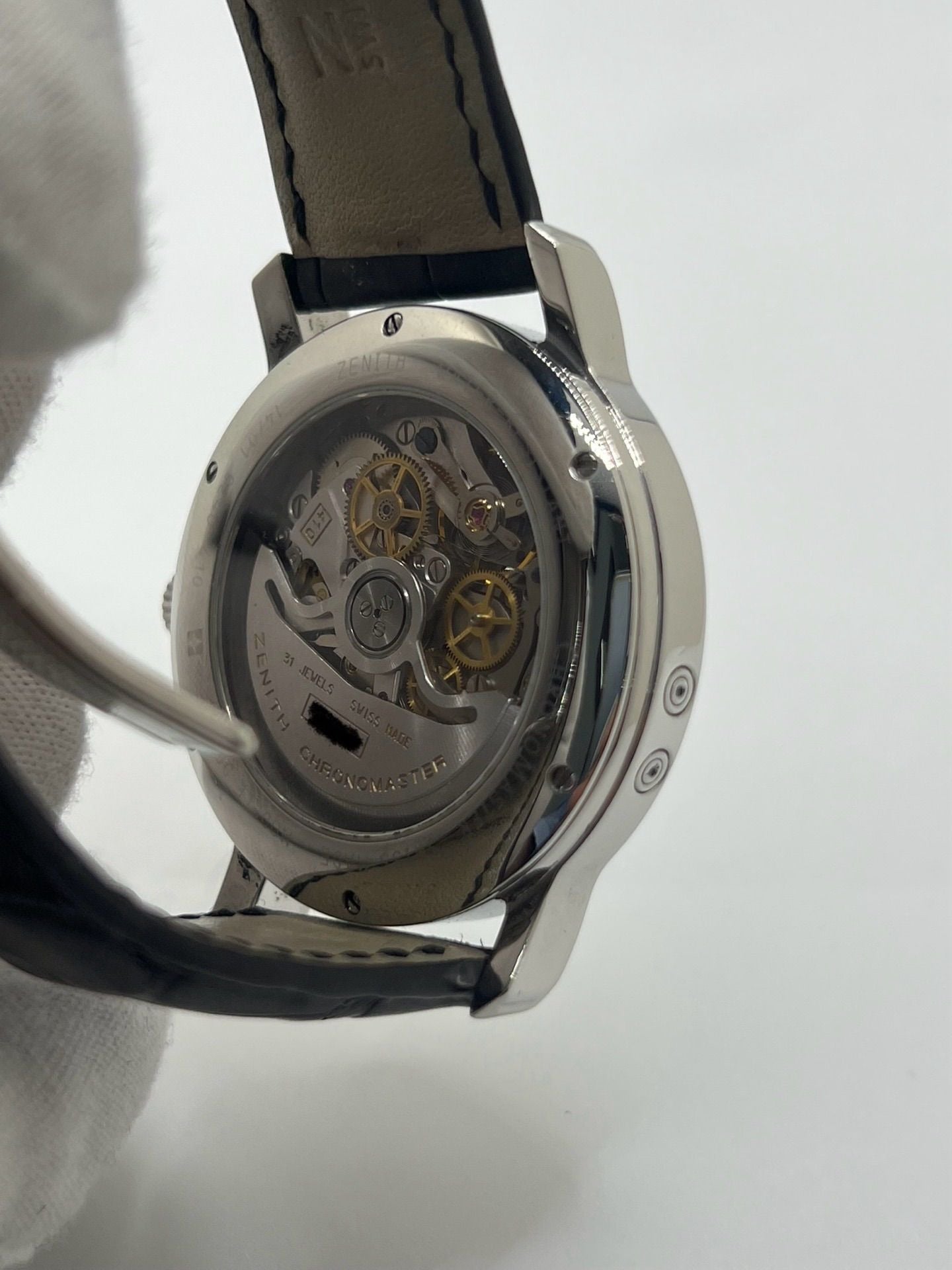 Montre chronographe automatique en acier avec cadran argenté à chiffres romains, fonction phase lunaire, date, jour et mois. Boîtier de 40 mm, verre saphir, fond transparent et bracelet en cuir noir. Modèle de haute précision doté du calibre 410 avec 50 heures de réserve de marche. Montre élégante pour homme ou unisexe.